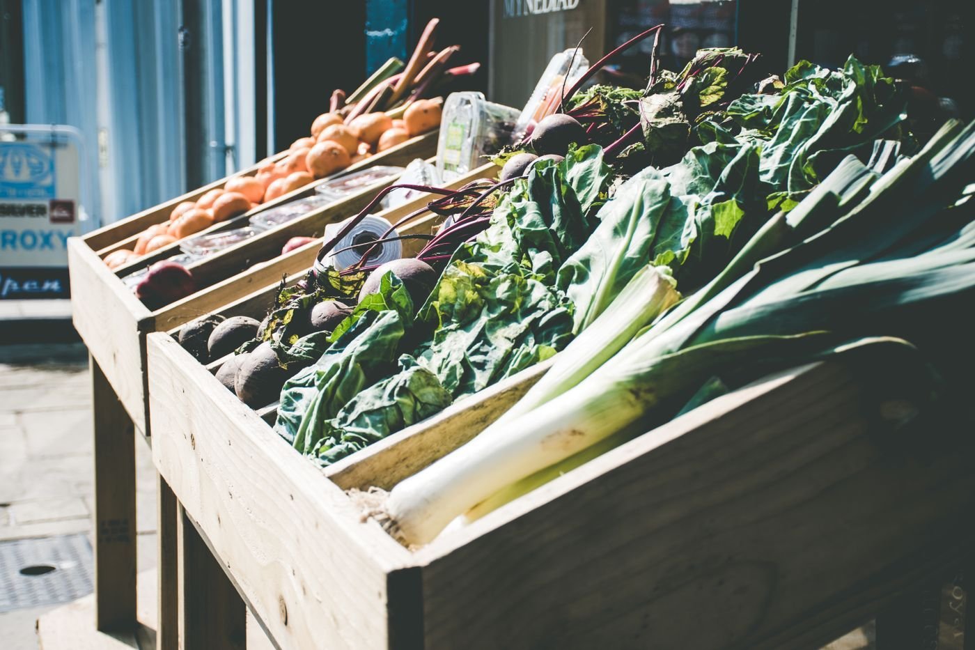 Market crates of leeks, chard and greens on a city street