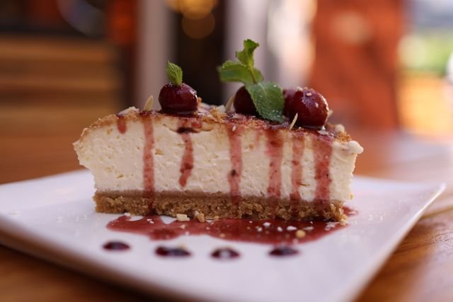 Cherry-topped cheesecake slice with cherry drizzle